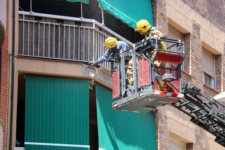Efectius dels Bombers de la Generalitat inspeccionant el tros de cornisa