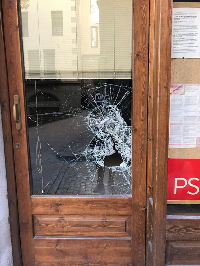 La porta de vidre del local del PSC de Solsona trencada per l'impacte d'una pedra