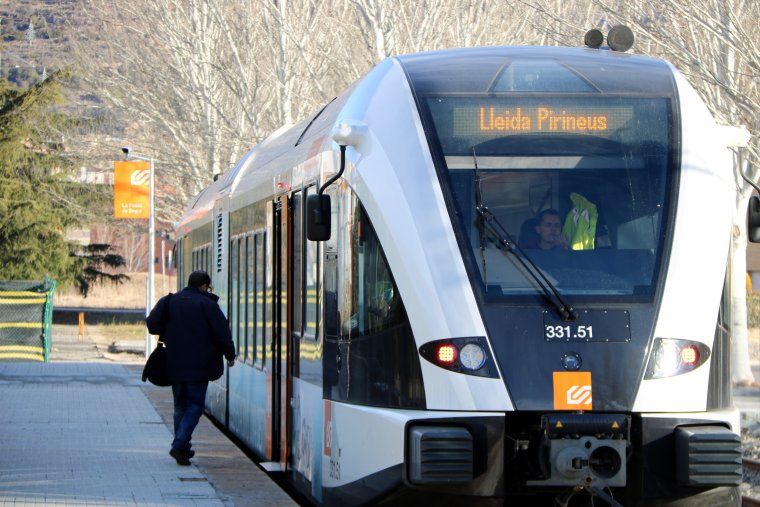 Un usuari pujant al tren a l'estació de la Pobla de Segur